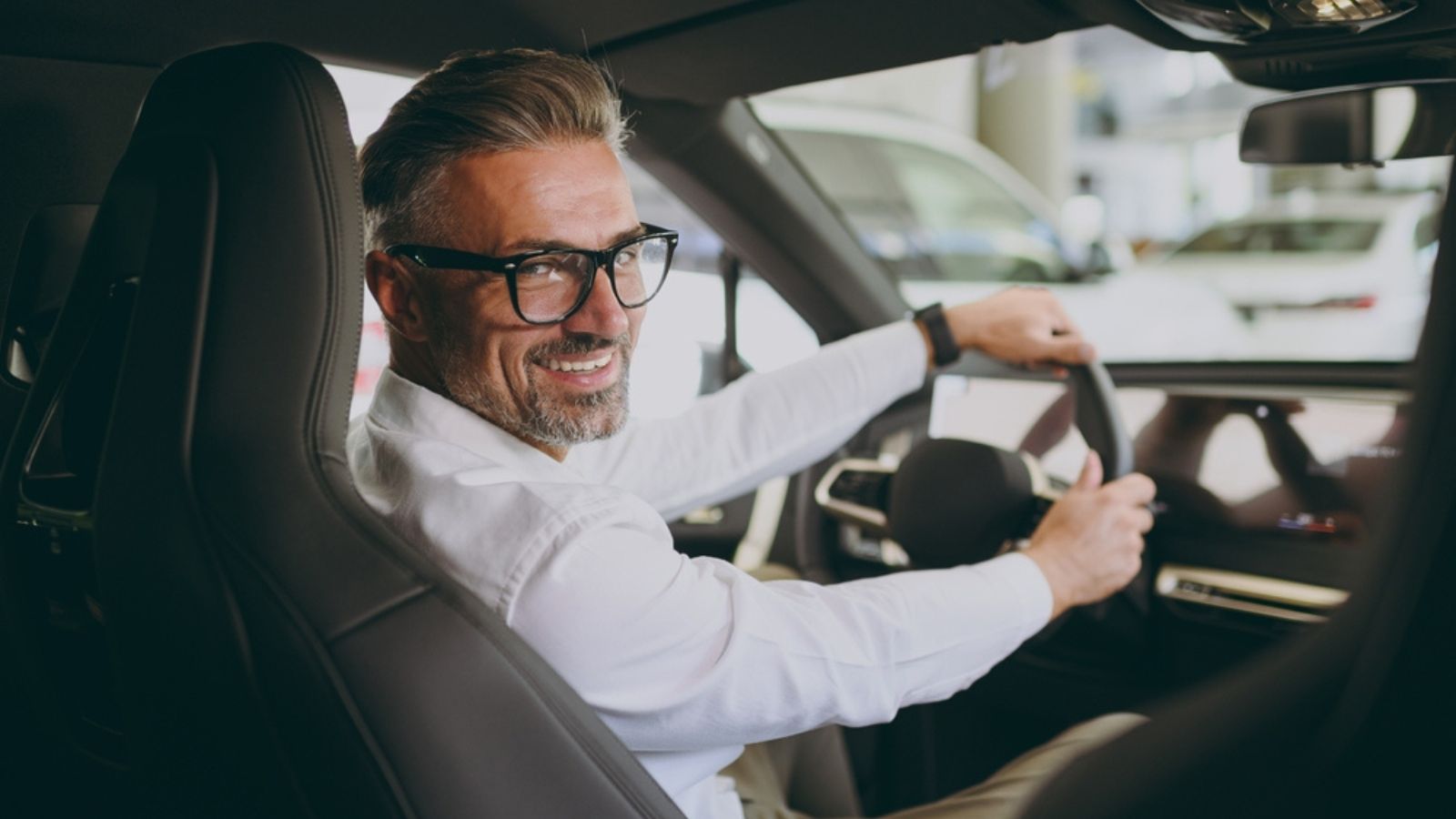 Back view adult man customer male buyer client wear shirt sit drive electric car look camera