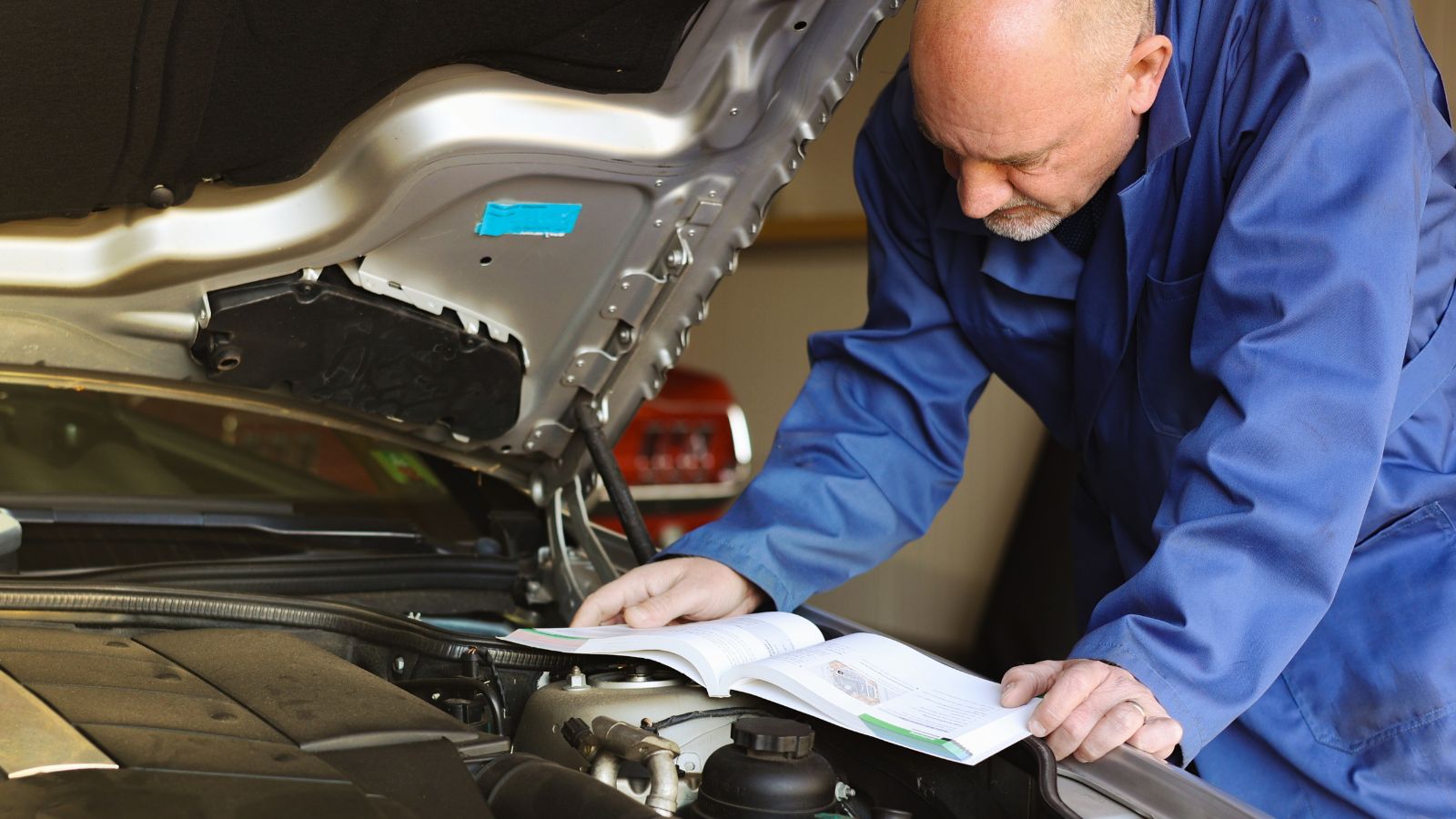 Mechanic reading car manual