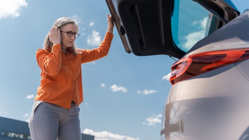 an older woman opening car trunk