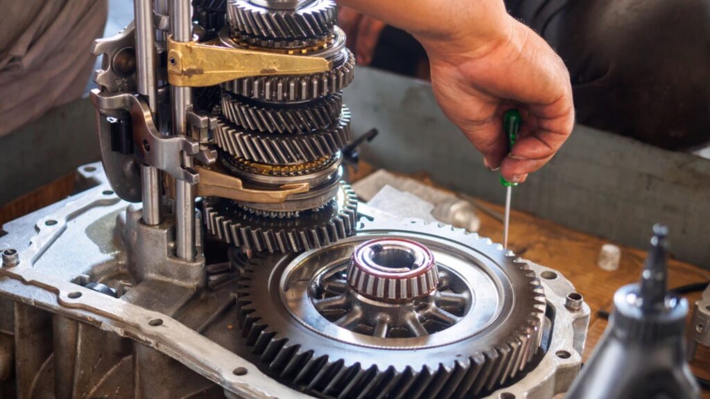auto mechanic repairing a manual transmission