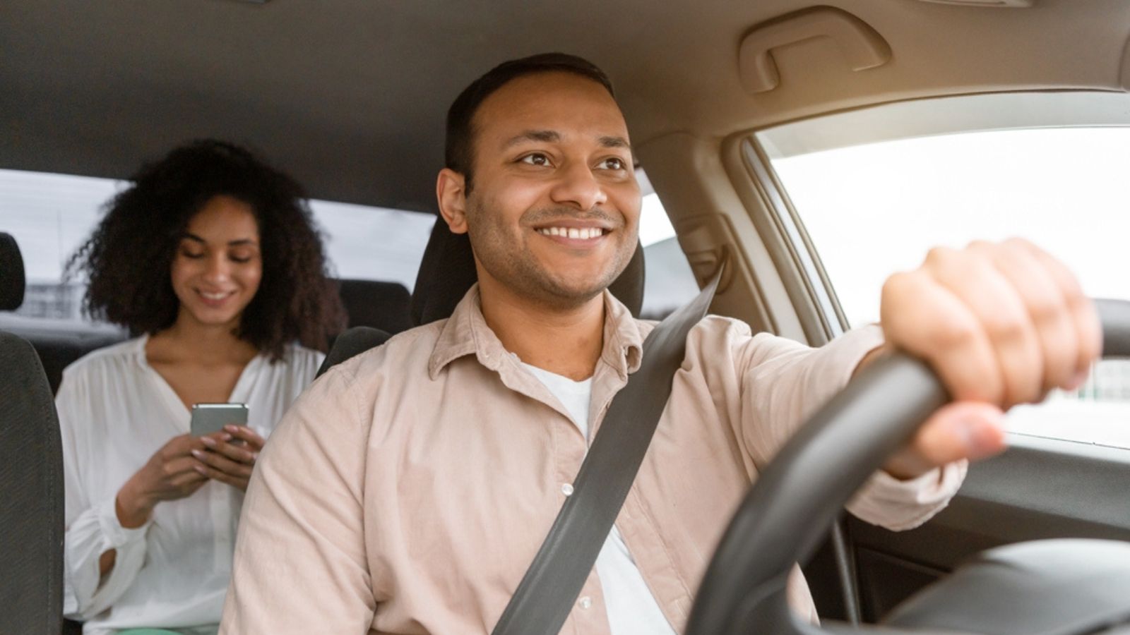 happy taxi man with woman customer using phone at the back
