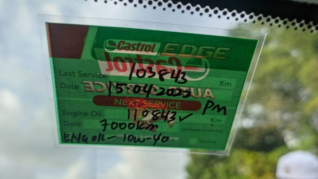 service sticker for engine oil is pasted on the inside of the car windshield
