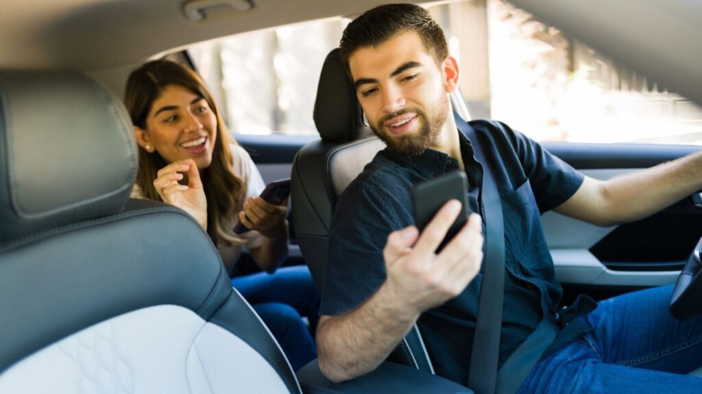 Handsome man driving a young woman passenger to her destination