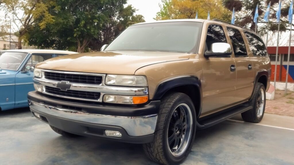 old beige Chevrolet Suburban full size SUV circa 2000 at a classic car show in a park