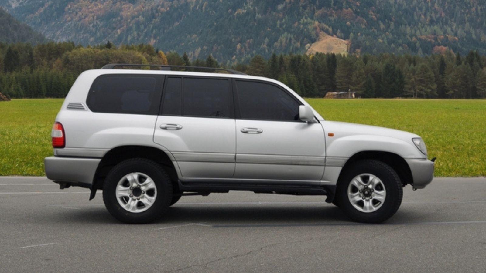silver Toyota Land Cruiser in parking lot in alpine countryside
