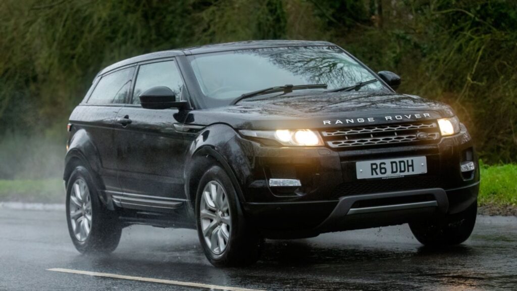 2014 diesel engine Range Rover Evoque car driving on a wet road, in the rain with headlights on