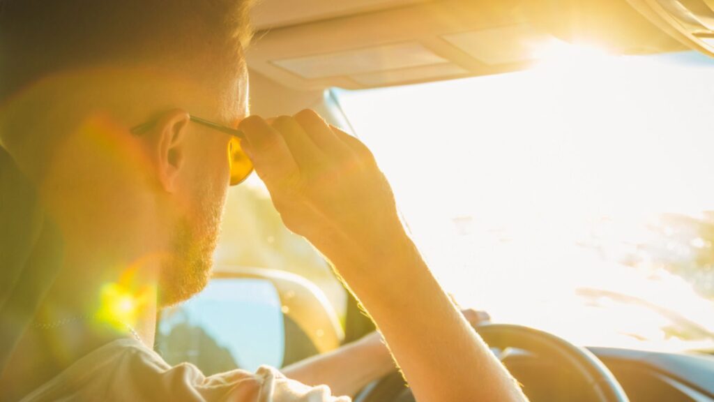 A man driving a car on a Sunny day