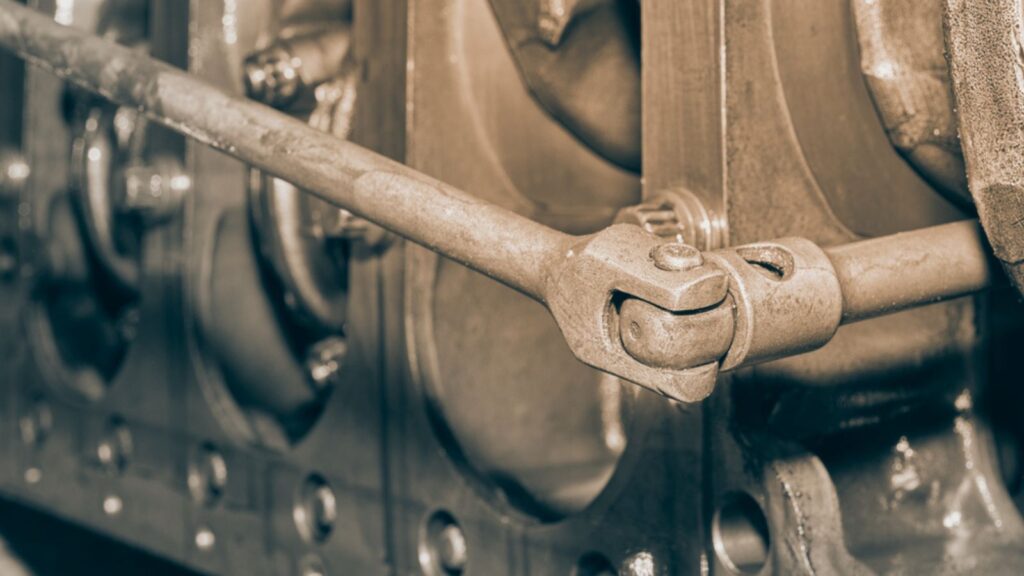 Auto Mechanic Use Breaker Bar Loosen Bolt of Crankshaft of Truck Engine