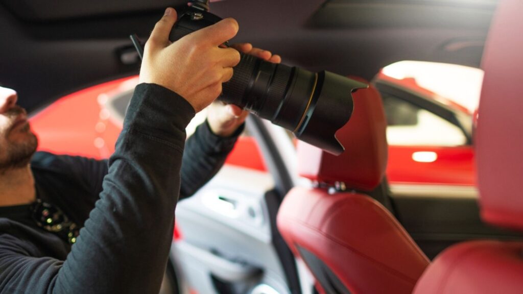Automotive Professional Photographer with Camera Inside Modern Luxury Vehicle with Burgundy Leather Seats