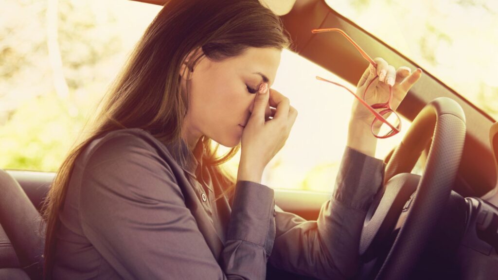 Business woman having headache taking off her glasses due to eye strain