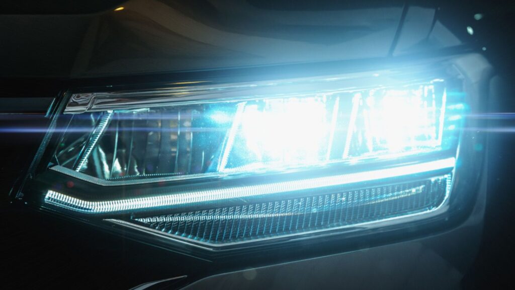 Car LED headlights in night. New modern car headlamp, close up