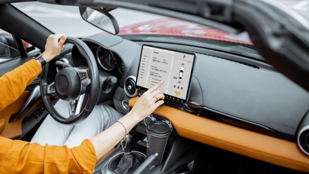 Cheerful woman controlling car with a digital dashboard