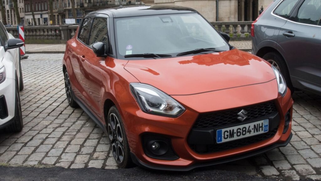 Front view of orange suzuki swift sport parked in the street