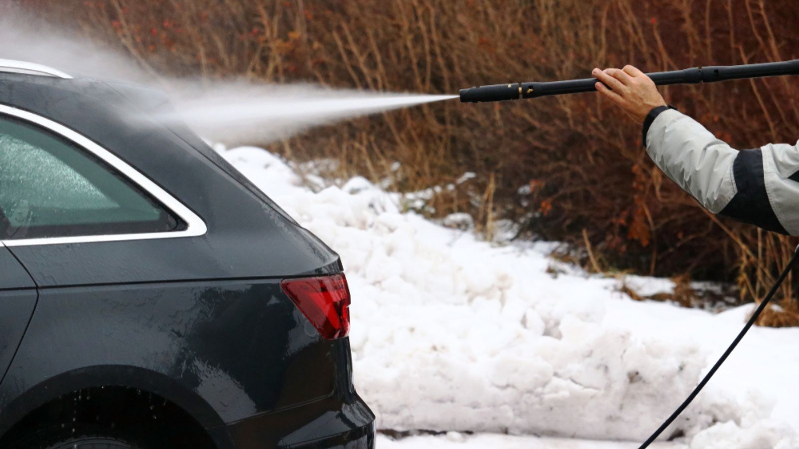 Man washing his car in the winter