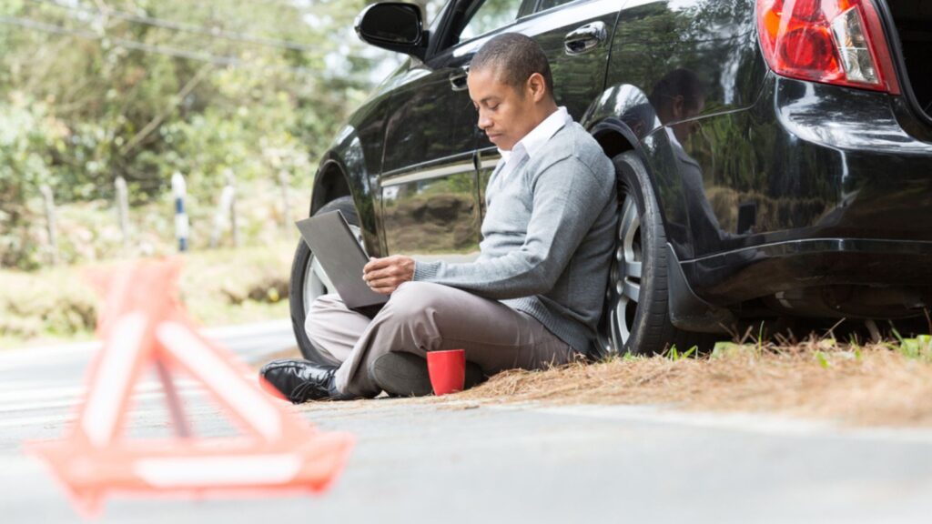 an African American man stranded on the road looking into your computer
