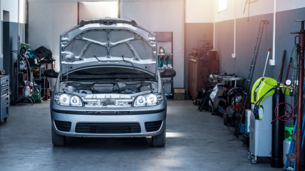 car with open hood in garage parking