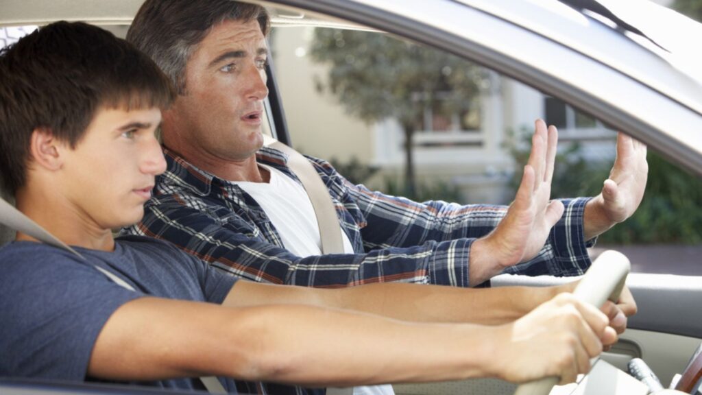 Nervous Father Teaching Teenage Son To Drive