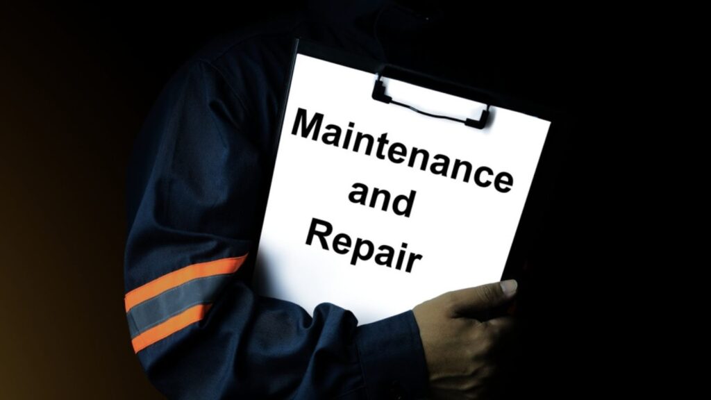 A maintenance engineer or technician holds a black filing document detailing the maintenance