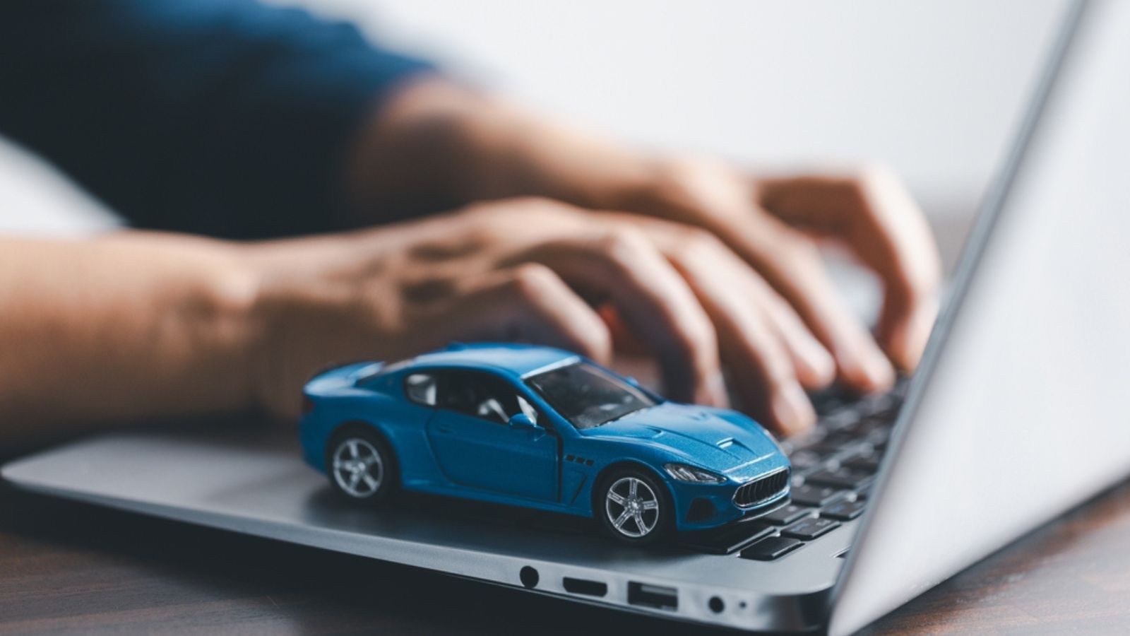 Close-up of a small red car on laptop keypad