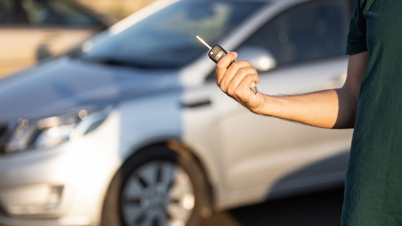 Cropped Image Close hands key-pressing remote system near the vehicle to lock