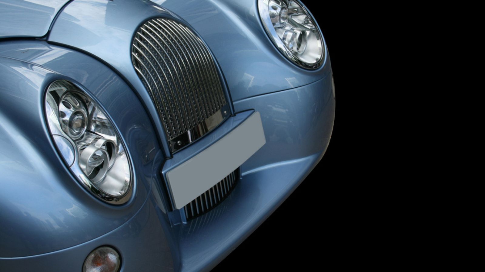 Retro metallic blue sportscar on a black background