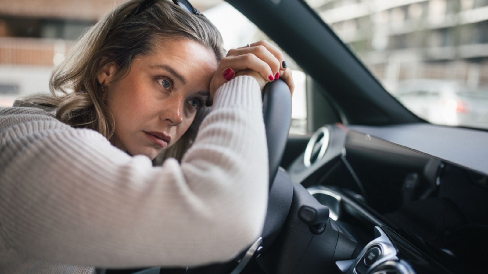 Upset woman driving her car in a city.
