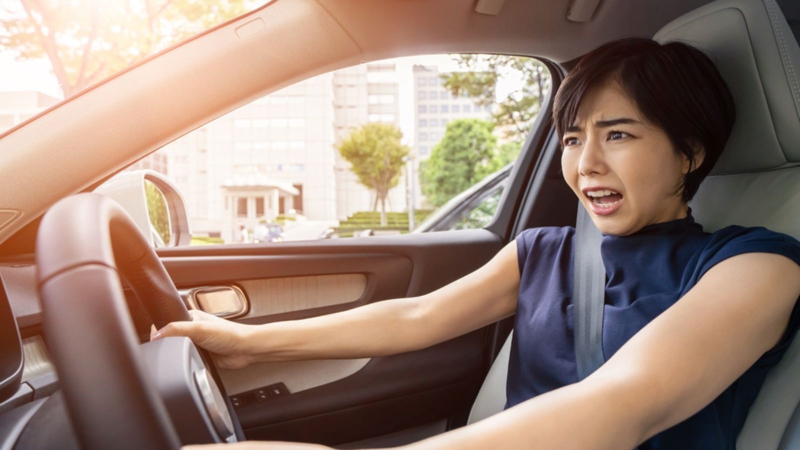 Young asian woman driving a car. Traffic accident.