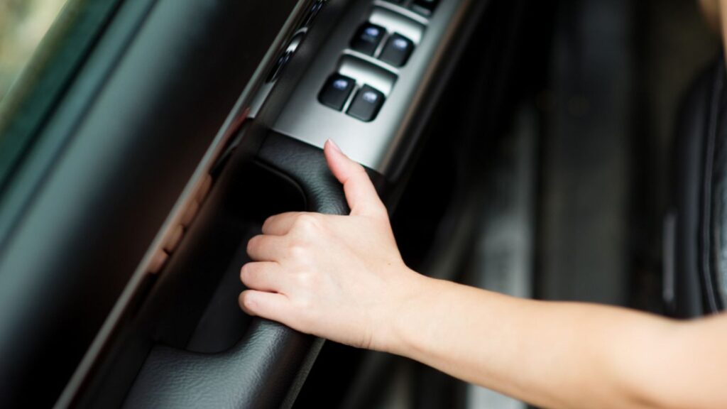 hand closing the door in the car