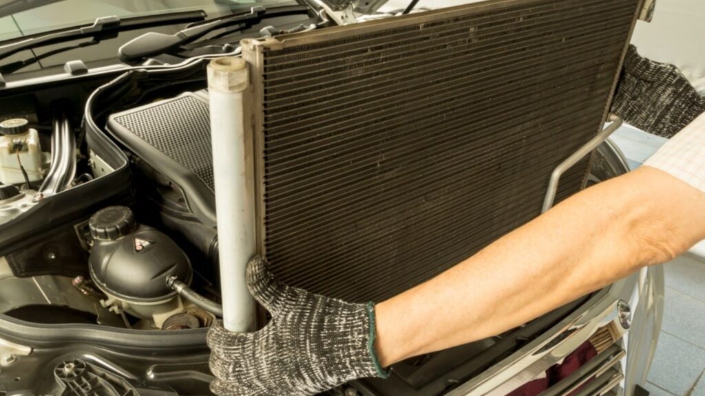Auto mechanic remove air conditioning condenser to maintenance