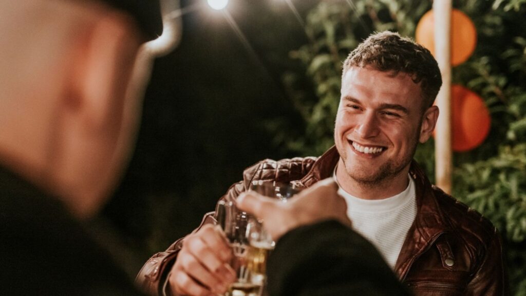 Happy male friends toasting to celebrate a Christmas dinner